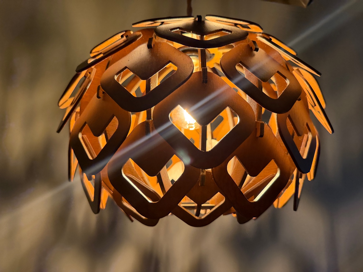 Laser-cut wood pendant luminary with warm light