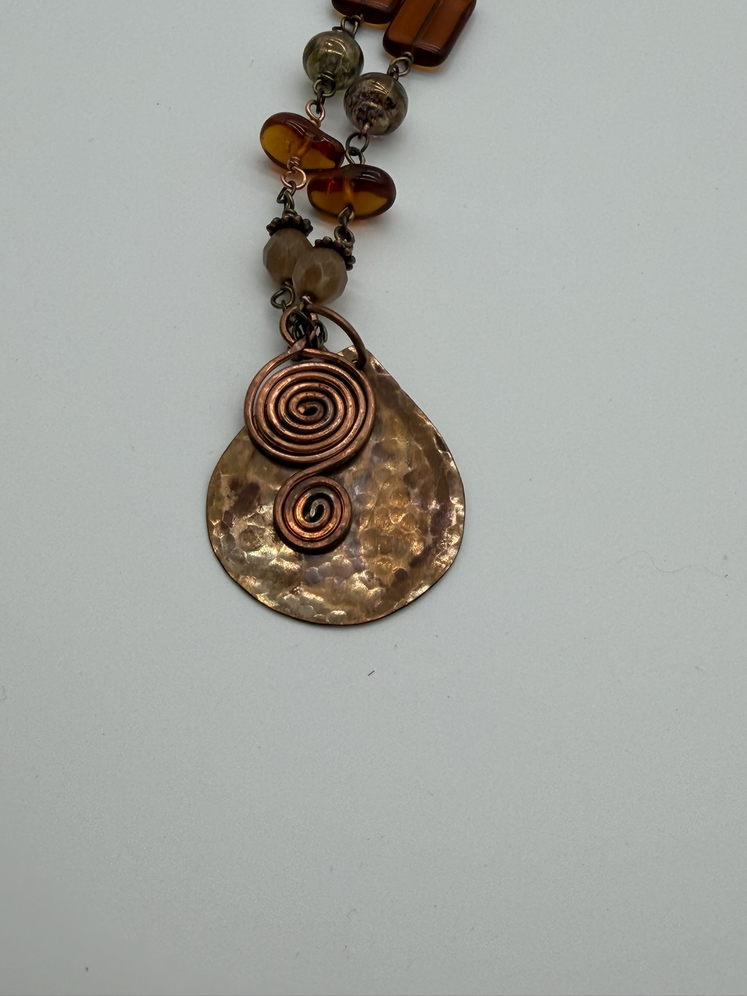 Hammered copper spiral pendant with amber beads
